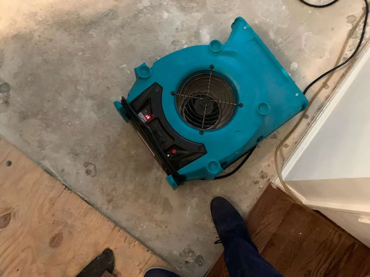 Air mover drying subfloor during Leak Detection & Repair in Suamico